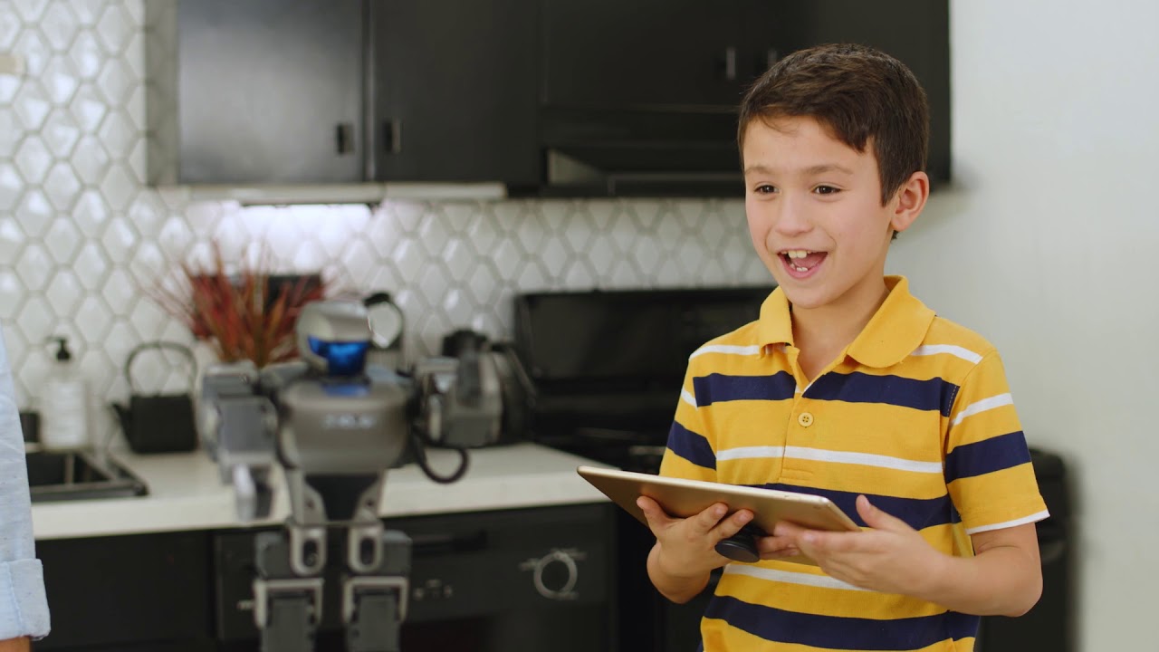 Un enfant joue avec le robot de Robosen